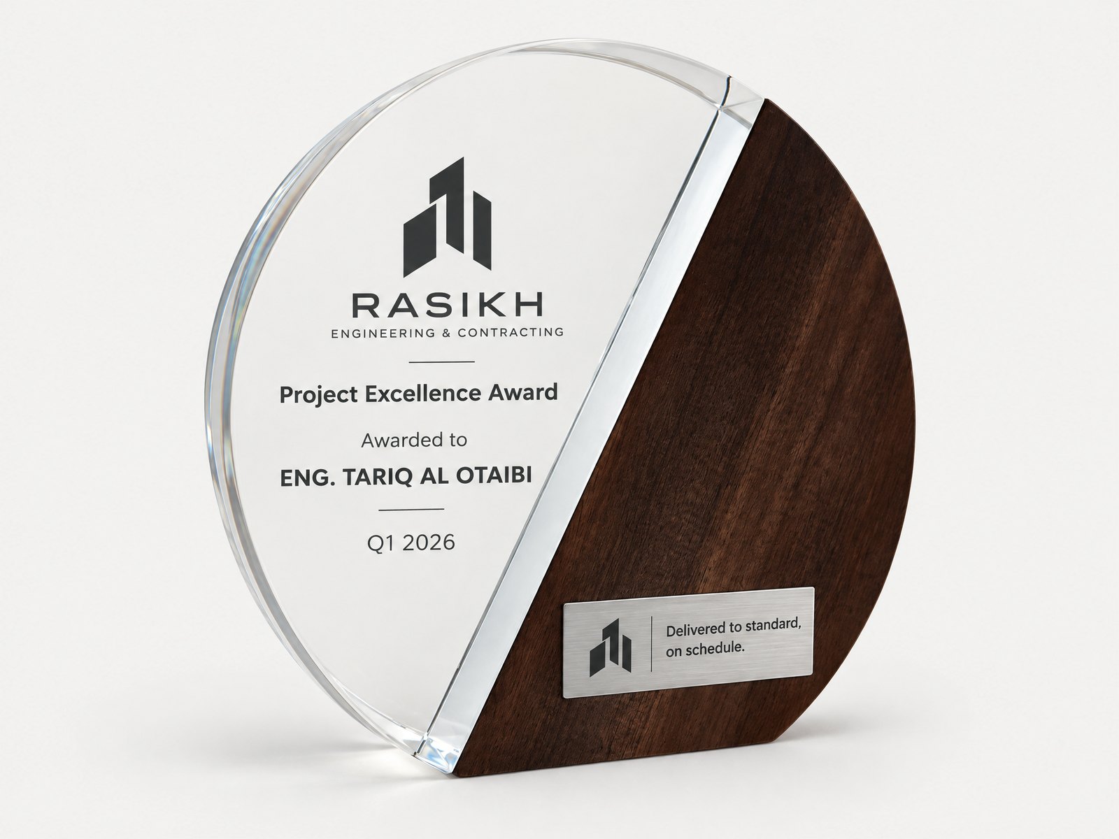A circular award split between clear crystal and walnut, finished with a brushed metal plate.