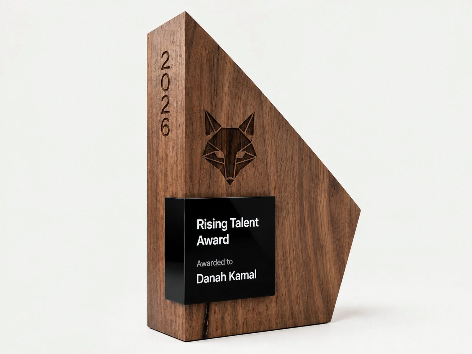 An angular walnut award with a black inset panel and engraved artwork.